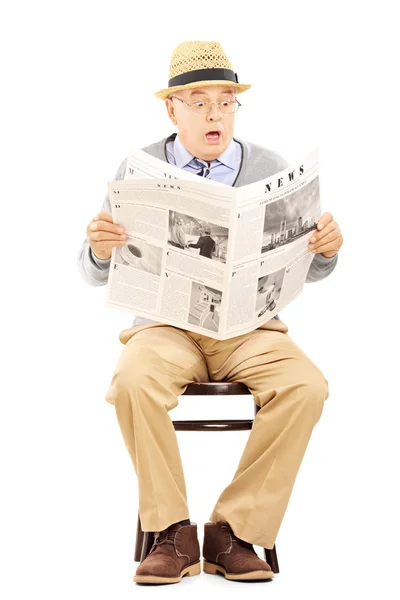 Senior gentleman in schok lezen van een krant — Stockfoto