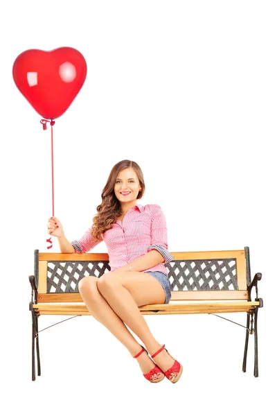 Woman on bench and holding balloon — Stock Photo, Image