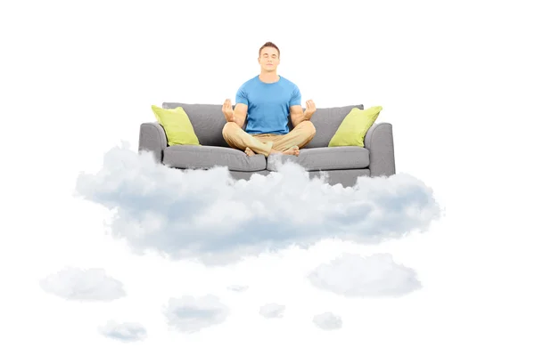 Hombre meditando en un sofá en la nube —  Fotos de Stock