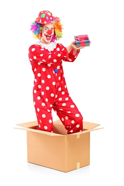 Clown in kartonnen doos houden geschenk — Stockfoto