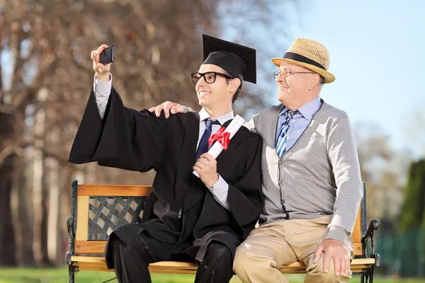 Graduate and father taking selfie — Stock Photo, Image