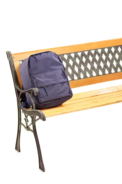 Wooden bench with school bag — Stockfoto
