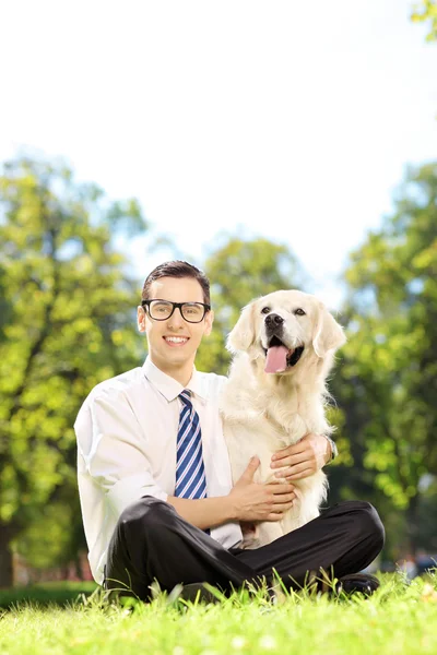 Мужчина обнимает свою собаку в парке — стоковое фото