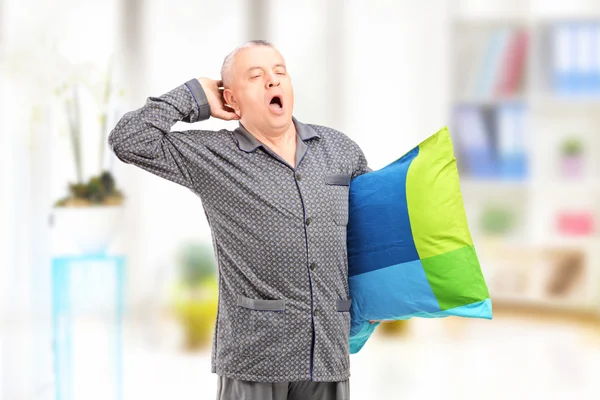 Man holding pillow and yawning — Stock Photo, Image