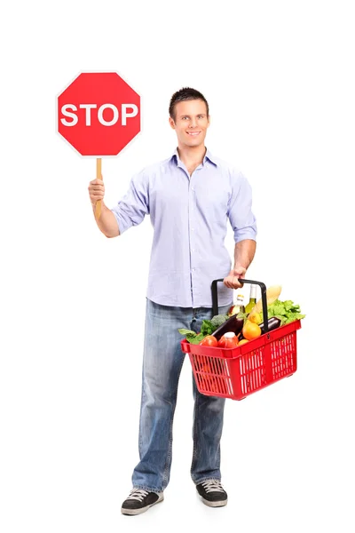 Mężczyzna trzyma koszyka i znak stop — Zdjęcie stockowe