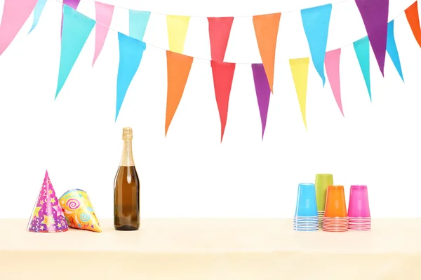 Bottiglia di vino, bicchieri e cappelli da festa — Foto Stock