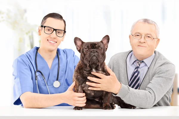 Senior met hond op een veterinaire praktijk — Stockfoto