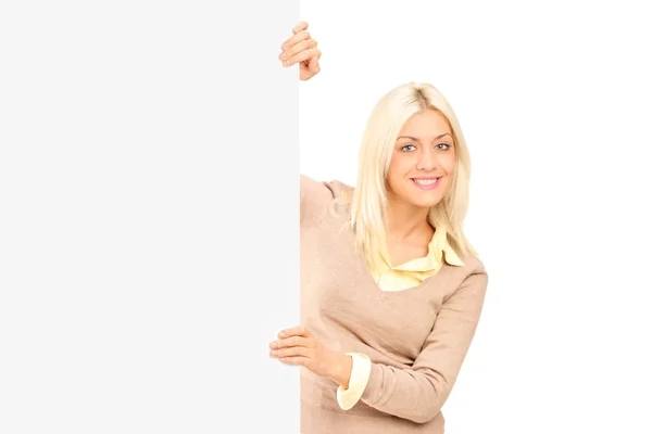 Casual girl standing behind a panel — Stock Photo, Image