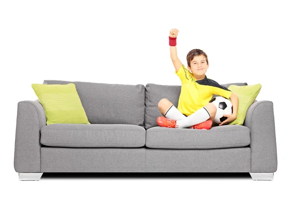 Jongen met voetbal op sofa — Stockfoto