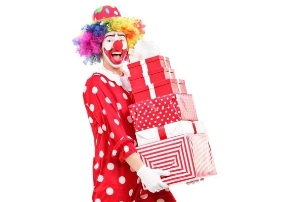 Clown trägt einen Stapel Geschenke — Stockfoto