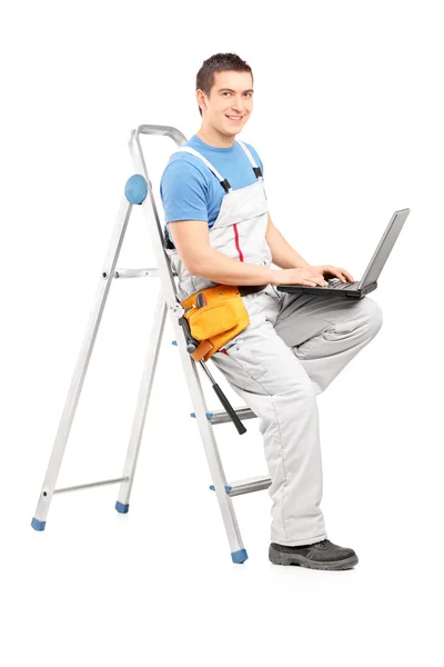 Man met laptop op ladder — Stockfoto