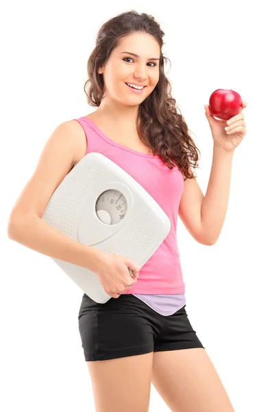 Female holding apple and weight scale — Stock Photo, Image