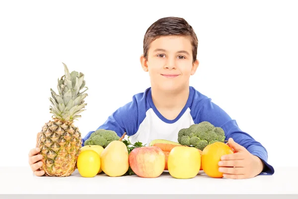 Jongen aan tafel van groenten en fruit — Stockfoto