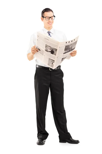 Стоящий и читающий газету бизнесмен — стоковое фото