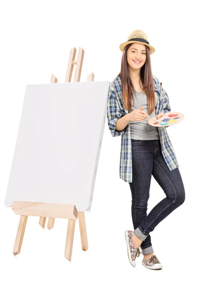 Artista feminina apoiada em uma tela em branco — Fotografia de Stock