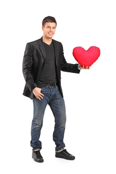 Man holding heart shaped pillow — Stock Photo, Image