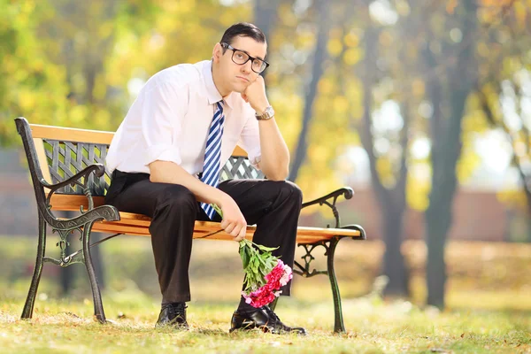 Sad man holding bouquet — Stock Photo, Image