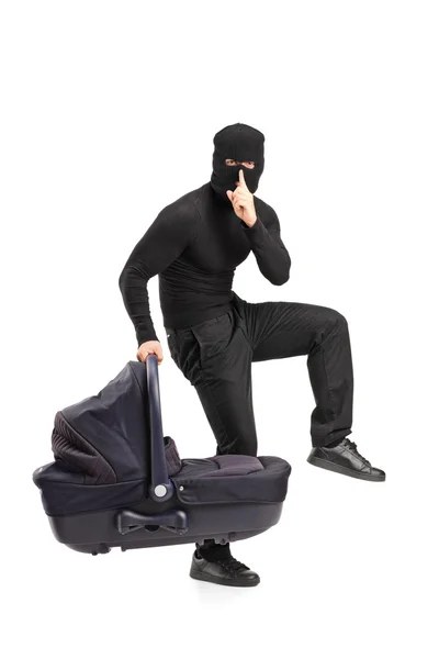 Man in robbery mask holding carrycot — Stock Photo, Image
