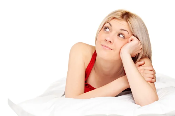 Thoughtful blond woman on bed Stock Photo