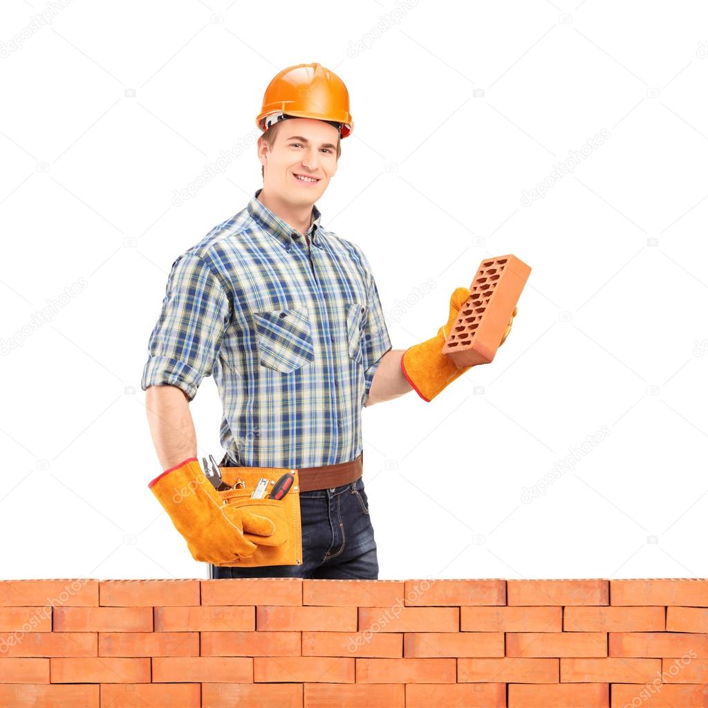 Male manual worker holding brick