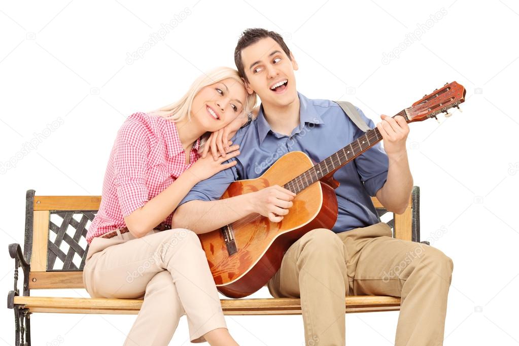 Guy playing guitar to his girlfriend