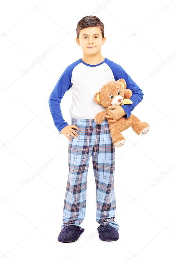 Boy in pajamas holding teddy bear