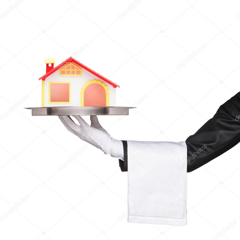 Waiter holding tray with house model