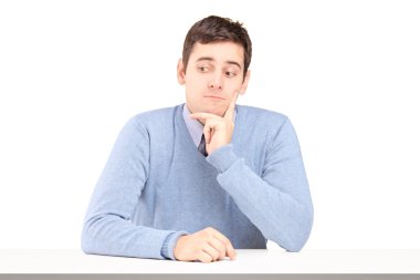 Masa başında oturup endişeli genç adam