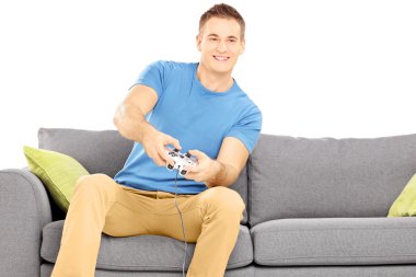 adam video oyunu oynarken bir kanepede