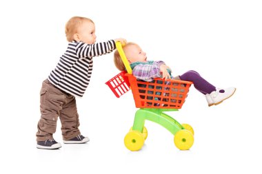 ikiz kardeş oyuncak sepeti iterek çocuk