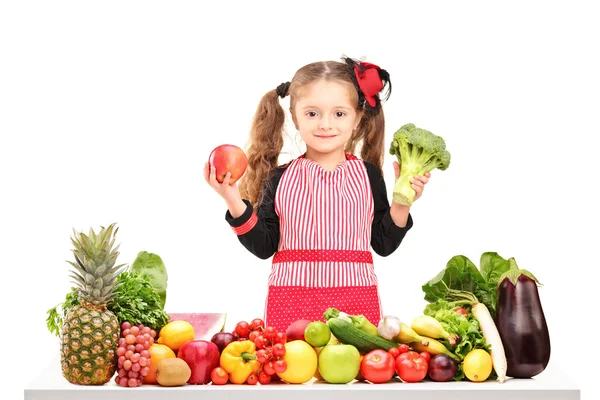 Girl holding broccoli and apple — Stock Photo, Image