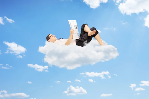 Hombre leyendo el periódico y en las nubes — Foto de Stock