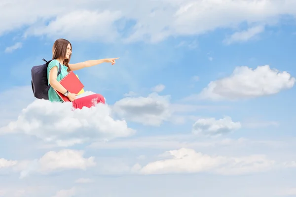 Estudiante señalando y sentado en una nube — Foto de Stock