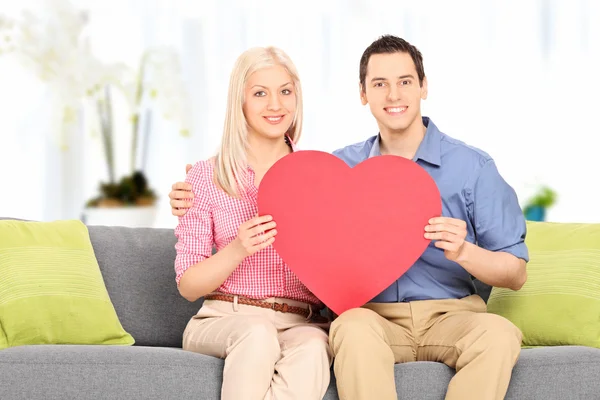 Casal segurando um grande coração vermelho — Fotografia de Stock