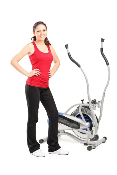 Feminino posando ao lado de cross trainer — Fotografia de Stock