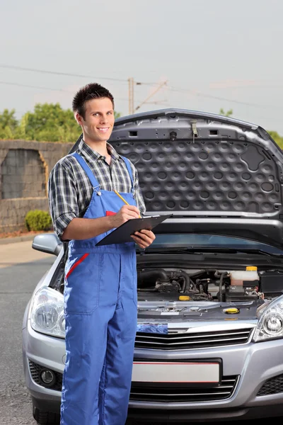Mechanic standing next to car — Stock Photo, Image