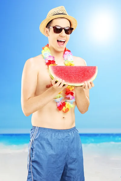 Mężczyzna jedzenie arbuza na plaży — Zdjęcie stockowe