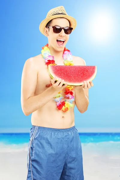 Uomo mangiare anguria sulla spiaggia — Foto Stock