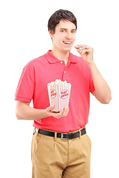 Молодой улыбающийся мужчина ест попкорн — стоковое фото
