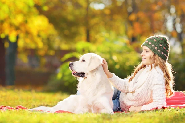 Kvinna liggande på gräs med hund — Stockfoto