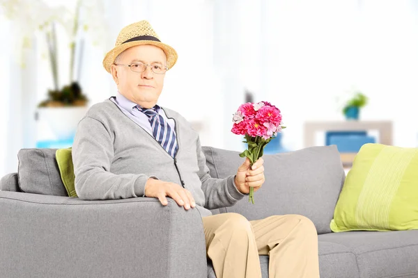 Senior sosteniendo flores en casa — Foto de Stock