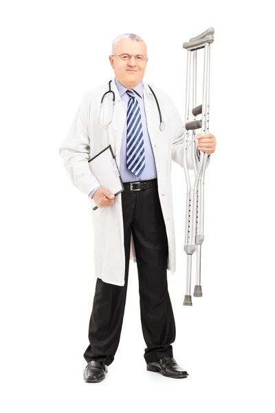 Medical doctor holding crutches — Stock Photo, Image