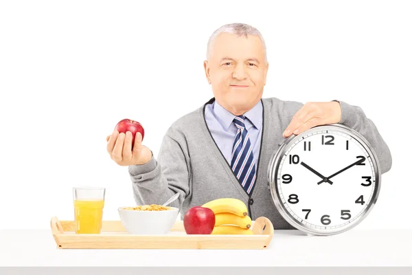 Caballero mayor sosteniendo un reloj — Foto de Stock