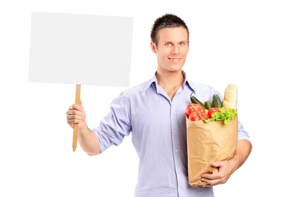 Male holding paper bag and blank panel — Stock Photo, Image