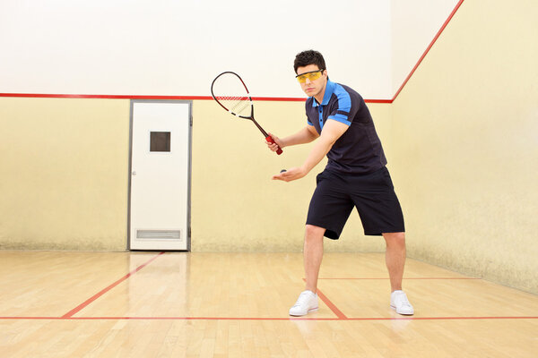 Squash player serving ball