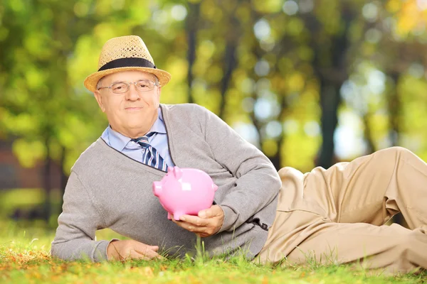 Mature gentleman holding piggy bank — Stock Photo, Image