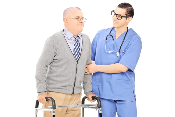 Infirmière aidant homme âgé avec marcheur — Photo
