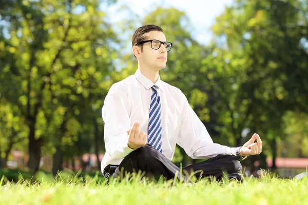 Uomo d'affari che medita su un'erba — Foto Stock