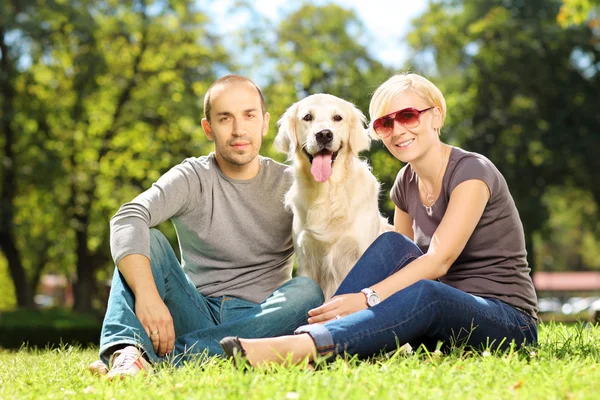 Casal jovem abraçando um cão — Fotografia de Stock