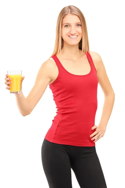 Atleta feminina segurando suco de laranja — Fotografia de Stock